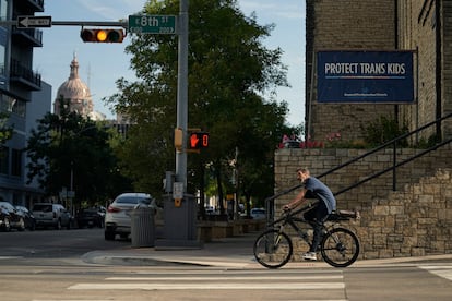 A cyclist passes a sign encouraging the protection of transgender children at Central Presbyterian Church near the Texas Capitol, on Aug. 15, 2023, in Austin, Texas.