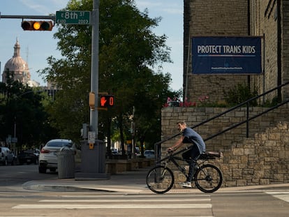 A cyclist passes a sign encouraging the protection of transgender children at Central Presbyterian Church near the Texas Capitol, on Aug. 15, 2023, in Austin, Texas.