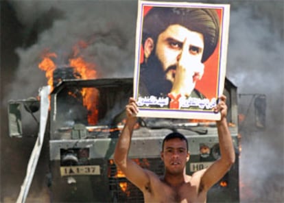 Un miembro de la milicia chií muestra un retrato del líder radical Al Sáder, en Bagdad.
