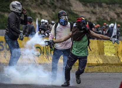 Un manifestante opositor al Gobierno de Nicolás Maduro lanza un bote de gas lacrimógeno a la policía durante una protesta en Caracas, el 24 de junio de 2017.
