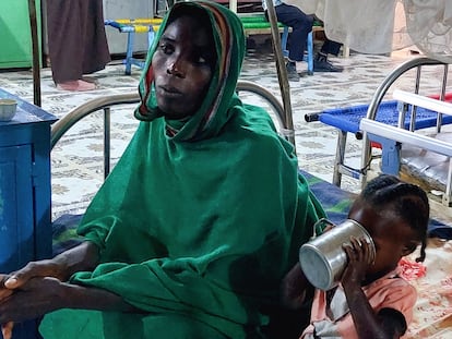 Una mujer y su hija esperan sentadas en el centro de nutrición del campo de Kalma, en Darfur (Sudán), el pasado 20 de febrero.