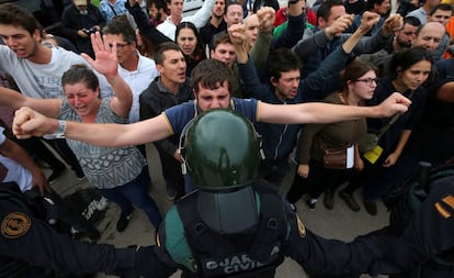 Um homem enfrenta um policial nos arredores de um colégio eleitoral em Girona.