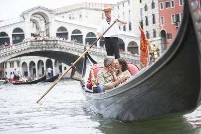 Una pareja se besa en una góndola en Venecia.