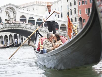 Una pareja se besa en una góndola en Venecia.