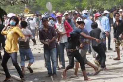 Trabajadores del sector textil lanzan piedras a la policía participan en una manifestación para pedir mejoras salariales en Phnom Penh (Camboya). EFE/Archivo