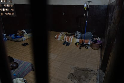 Tres pacientes dormitan en colchones en el suelo tras los barrotes de la sala de urgencias del centro Sajed para drogodependientes de Conakry.