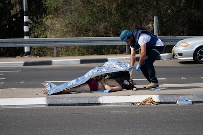 An Israeli police officer covers a fallen Palestinian attacker near the Gaza Strip, on the outskirts of Ashkelon.
