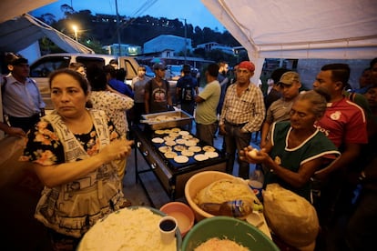 Algunas personas preparan tortillas en el polideportivo de Santa Rosa de Copán, Honduras, la noche del 13 de octubre de 2018. 