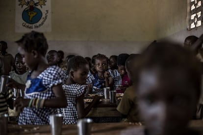 Una niña observa mientras come en el comedor escolar en el campamento de Bodouakro.
