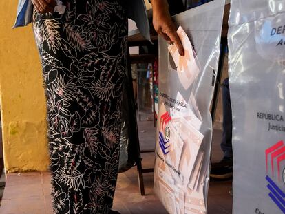 Una mujer deposita su voto en una urna en un colegio electoral en la ciudad de Mariano Roque Alonso, este domingo.