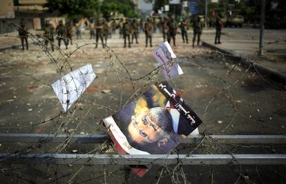 Un poster con el retrato del expresidente egipcio Mohamed Morsi situado en el alambre de espino que protege los alrededores de la sede de la Guardia Republicana, 9 de julio de 2013. La tensión continúa en Egipto tras la muerte ayer de al menos 51 personas, en su mayoría islamistas, y la decisión del presidente interino, Adli Mansur, de celebrar las próximas elecciones legislativas antes que las presidenciales.