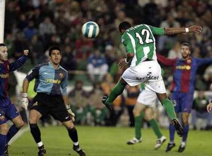 Robert cabecea el gol del Betis ante la mirada de Valdés, el portero del Barça, y sus compañeros.