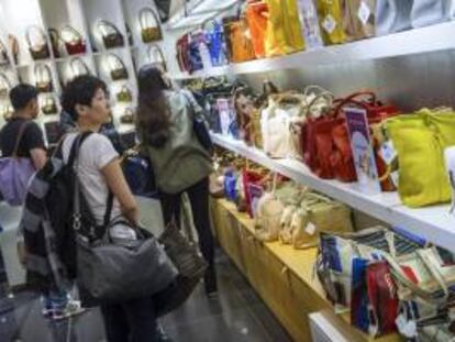 Una mujer observa una colección de bolsos en las Galerías Lafayette en París (Francia). EFE/Archivo