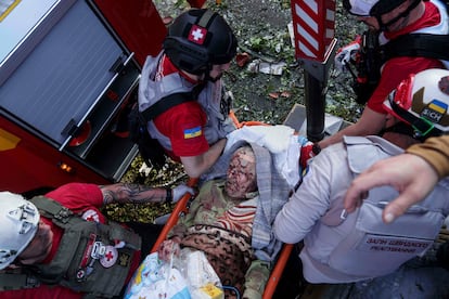 Persona de emergencia trasladaba este martes a uno de los heridos en un bombardeo ruso sobre un edificio en Kiev, la capital ucrania.