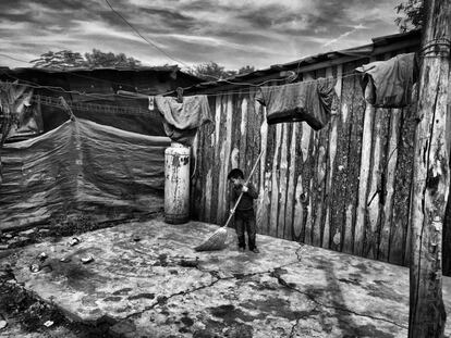 Marco Antonio, un niño de 8 años, limpia su improvisada casa de madera donde vive con sus padres y cuatro hermanos. Hasta hace 5 meses su vivienda estaba en la comunidad El Carrizal. Históricamente, los grupos de crimen organizado sinaloense han controlado ese territorio ya que es un punto geográfico estratégico para el tráfico de drogas desde México a Estados Unidos.