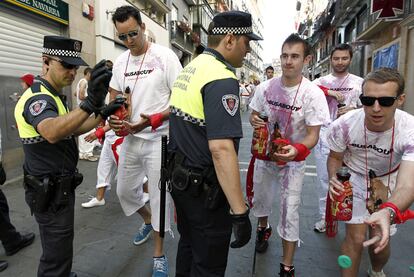 Agentes de la Policía Municipal de Pamplona retiran los tapones de las botellas antes de que los mozos entren a la Plaza del Ayuntamiento en donde el alcalde de esa ciudad, Enrique Maya, fue el encargado de prender la mecha del cohete anunciador de los Sanfermines.