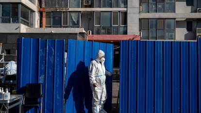 Un trabajador con equipo de protección en un barrio bajo confinamiento, el lunes en Pekín.