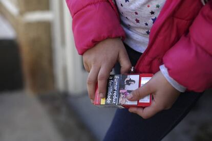 Natasha, de ocho a&ntilde;os, sujeta un paquete de tabaco . 