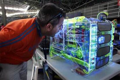 Un asistente al Campus Party observa un ordenador en  la feria.