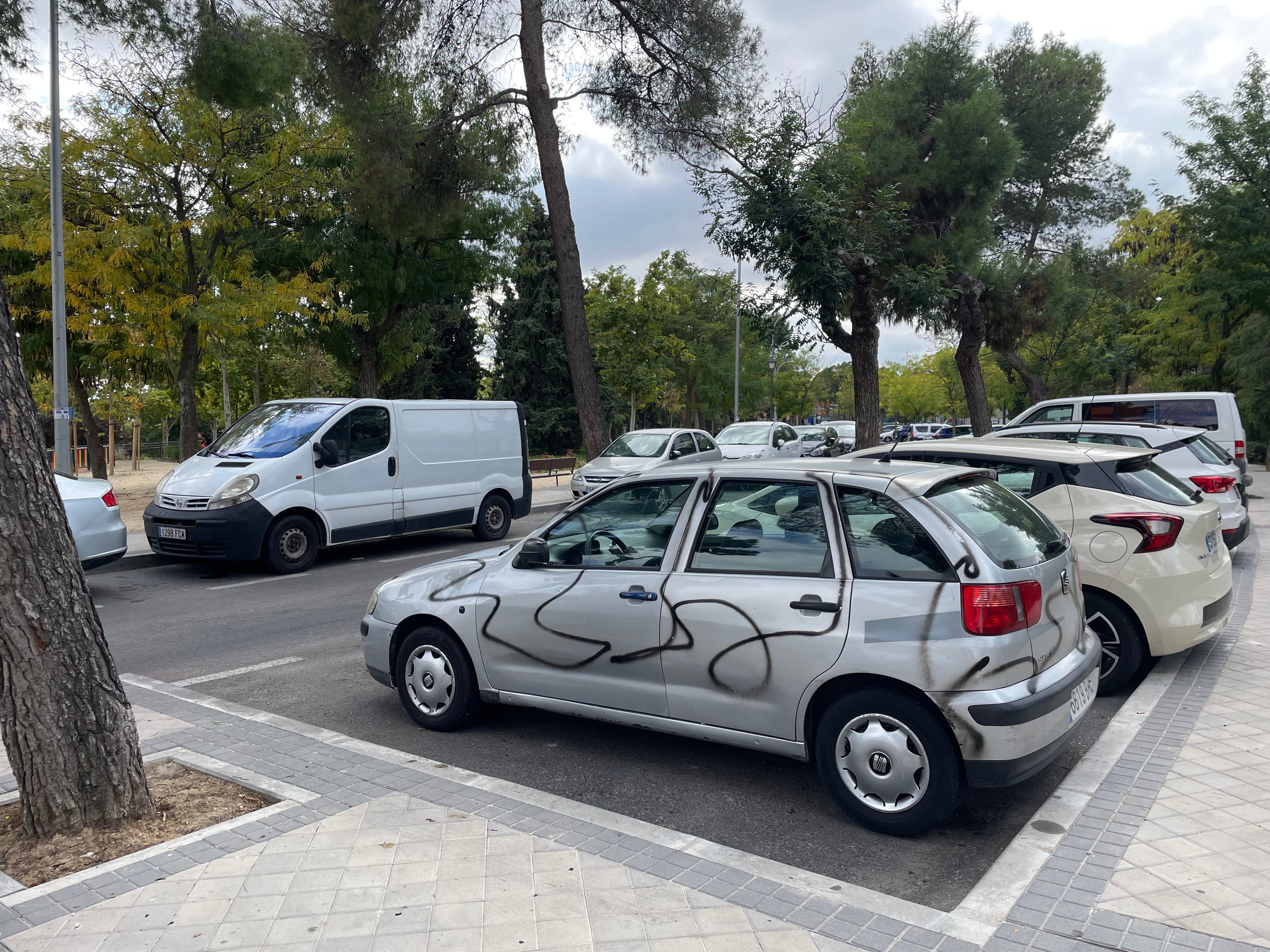 Uno de los coches vandalizados con pintura en espray en la calle de Cerecinos, en Usera.