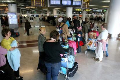 Pasajeros esperan haciendo cola en la zona de embarque del Aeropuerto del Altet, en Alicante.