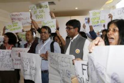 Activistas sostienen pancartas y gritan consignas durante una protesta en contra de la Organización Mundial del Comercio (OMC) a la salida de la sala de conferencias donde se celebra la novena conferencia ministerial de la OMC en Nusa Dua, Bali (Indonesia) hoy.