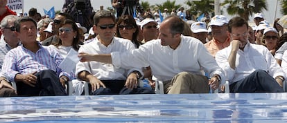 Federico Trillo, Vicente Rambla, Francisco Camps y Mariano Rajoy durante el acto de campaña. Camps parece pasarle una nota a Trillo, mientras Rajoy mantiene la mirada baja, perdida.