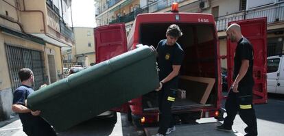 Tres de los voluntarios de Bomberos Ayudan entregan unos muebles en un domicilio de Villaverde Alto.