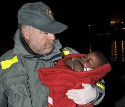 Un guardia civil sostiene al bebé rescatado.