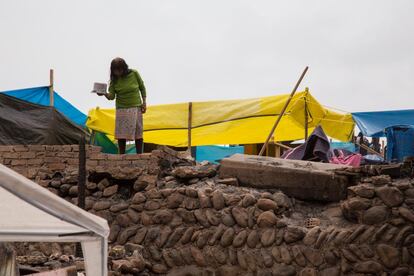 Una mujer limpia una olla en medio de los escombros. Una de las reivindicaciones de los vecinos, incluso antes del incidente, era tener acceso a agua potable, saneamiento y luz en la zona. 