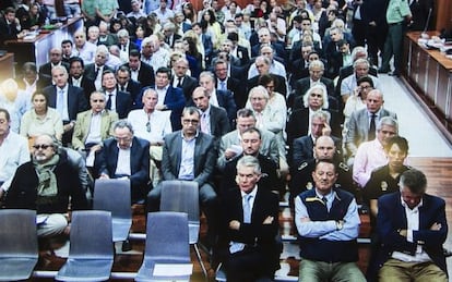 A photograph taken of a monitor screen outside the Málaga courtroom as the defendants prepared to hear the sentence. Former Marbella Mayor Julián Muñoz is second from the right in the front row, next to Juan Antonio Roca (head bowed),