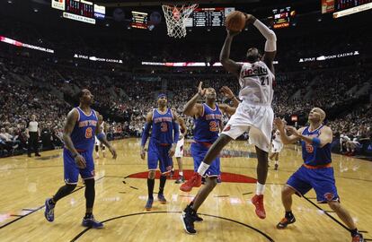 J.J. Hickson, de los Blazers, lanza rodeado de jugadores de los Knicks.