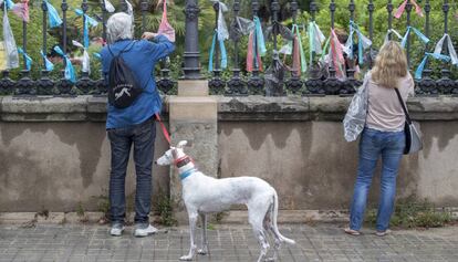 Gent collant llaços multicolors a la Ciutadella.