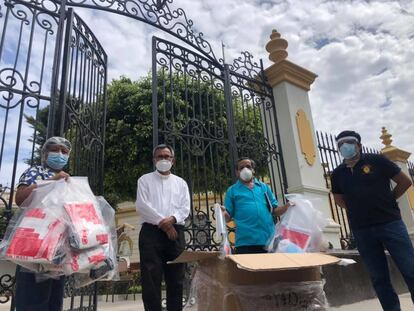 El párroco José Manuel Zamora y el fiscal Juan Carrasco entregan alimentos en Chiclayo, en Perú, en mayo.
