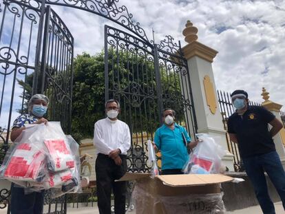 El párroco José Manuel Zamora y el fiscal Juan Carrasco entregan alimentos en Chiclayo, en Perú, en mayo.