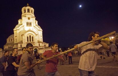 Unos manifestantes construyen barricadas en el exterior del Parlamento de Sofía (Bulgaria), 23 de julio de 2013. Los legisladores no pudieron salir del Parlamento hasta la madrugada, después de que en un primer intento de evacuarlos en autobús cinco horas antes fuera frustrado por la presencia de miles de personas que rodeaban el edificio.