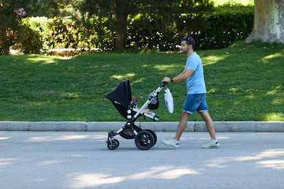 Una persona pasea con un carrito de bebé en el parque de El Retiro, en Madrid