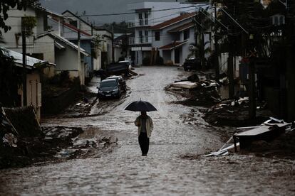 Un hombre se resguarda de la lluvia con un paraguas mientras camina por las calles de Mucum (Estado de Rio Grande do Sul), el 11 de mayo.