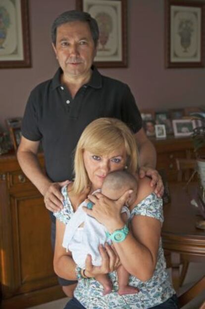 Julio y Teresa, padres de acogida urgente, posan con Paula en el salón de su casa.
