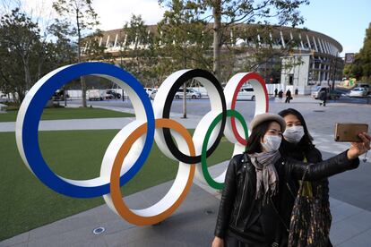 Dos mujeres se hacen un selfie ante el Estadio Olímpico de Tokio.