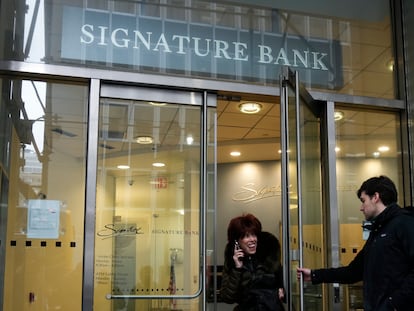 A woman leaves a branch of Signature Bank in New York, Monday, March 13, 2023.