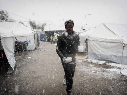 Un migrante camino bajo una nevada en un campamento de la isla de Lesbos, en Grecia.