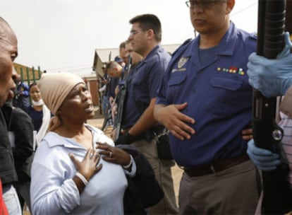 Una anciana surafricana pide a Robert McBride (con la mano en la tripa) que no cargue contra los manifestantes en los incidentes del pasado mayo.