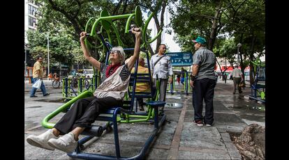 Una anciana hace sus ejercicios diarios en un gimnasio urbano levantado en la plaza Largo Do Machado.