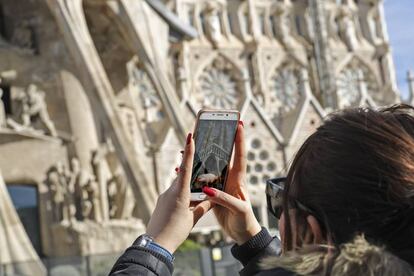 Una mujer fotografía la Sagrada Familia.