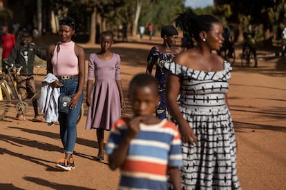 Bellefille, de 19 años, y Alliance, de 14, caminan junto a sus familias por las calles de Jurú, en el distrito ruandés de Bugesera. Las dos familias han participado en el programa de la ONG Interpeace, apoyado por el Gobierno ruandés y la Unión Europea y destinado a sanar el trauma social que aún perdura en comunidades, casi 30 años después del genocidio en el país africano.