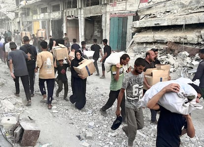 Decenas de palestinos con cajas de alimentos, el 1 de julio, en Jan Yunis, sur de Gaza, donde la Fundación Humanitaria de Gaza (GHF) empezó a distribuir comida el 27 de mayo.