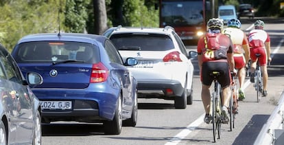 Tres ciclistas circulan por una carretera de Valencia. 