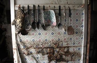 Interior de una cocina de una casa abandonada en Press Park, con utensilios colgando aún de las paredes.