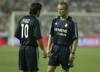 Figo y Beckham conversan en el partido del sábado en Mestalla.